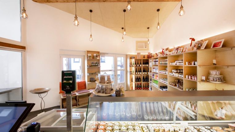 Ein einladendes Geschäft mit hellen Regalen und einem gut gefüllten Kühlbereich. Die warmen Lichter sorgen für eine gemütliche Atmosphäre.