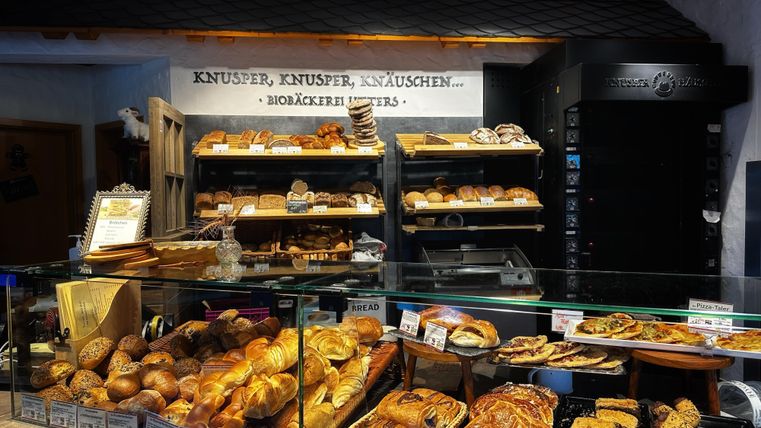 Een bakkerij met een verscheidenheid aan verse gebakken goederen. Broden, gebak en zoete lekkernijen zijn aantrekkelijk gepresenteerd.