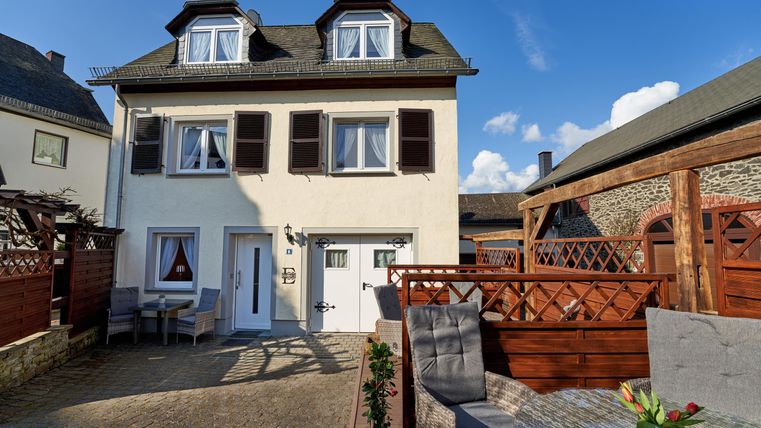 A charming house with a clear sky in the background. The outdoor area is well-designed and invites relaxation.