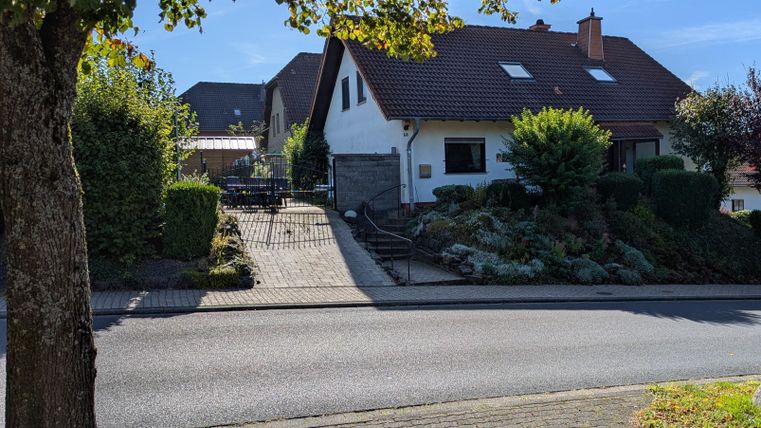 Een gezellig eengezinswoning met een verzorgde tuin. De straat is rustig en omzoomd met bomen.