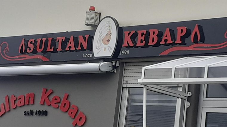 Ein Restaurant namens "Sultan Kebap". Die Fassade zeigt ein großes Schild mit dem Namen und einem modernen, einladenden Design.