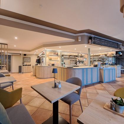 A modern café with bright interiors and a friendly atmosphere. The counter is well-stocked and invitingly designed.