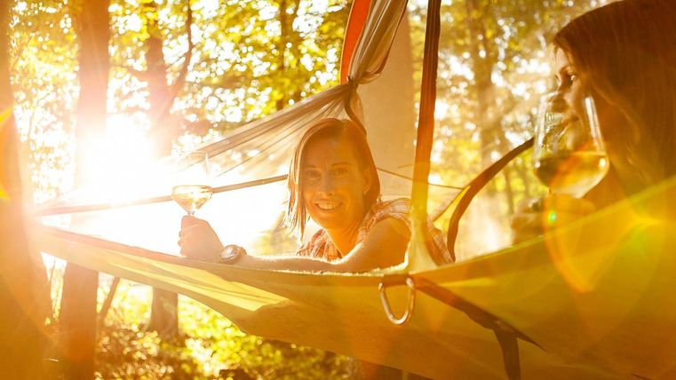 two women in a tree tent in the evening sun