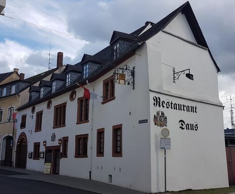 Ein traditionelles Restaurant mit weißer Fassade und einem charakteristischen Dach. Das Gebäude hat große Fenster und einladende Schilder.