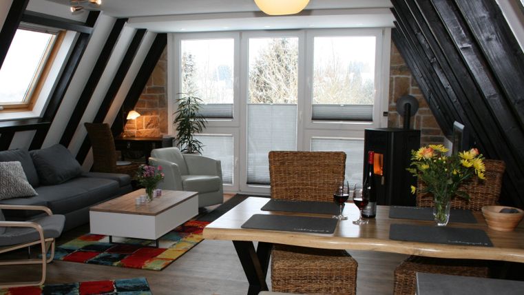 Een gezellige woning met moderne meubels en een grote tafel. Grote ramen zorgen voor veel daglicht en een uitnodigende sfeer.