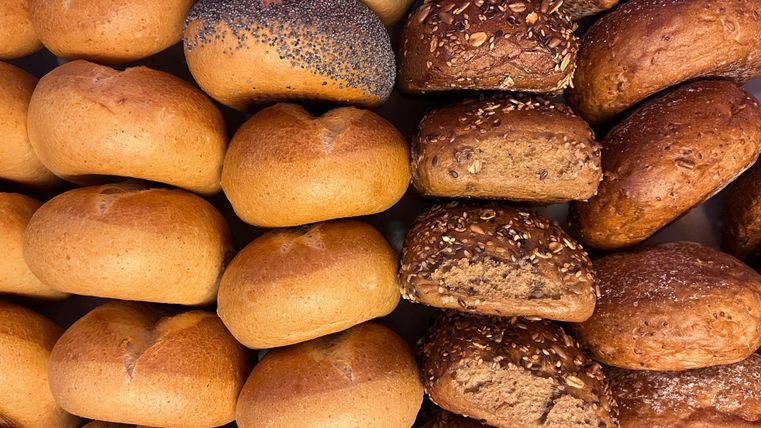 Een selectie van verse broodjes in verschillende soorten. De broodjes zijn goudbruin en mooi gepresenteerd.