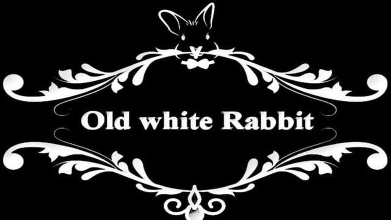Ein stilvolles Schild für das "Old white Rabbit" Pub. Es zeigt den Slogan "Der einzig wahre Wohlfühlpub!" in einer dekorativen Schriftart.