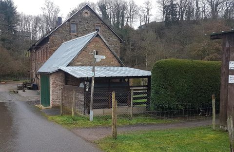 Ein altes Haus mit einem Satteldach und einer grünen Tür. Der Weg führt an einem gepflegten Garten vorbei.