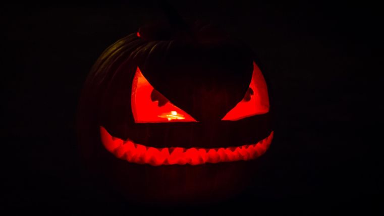 Kürbis mit rot leuchtenden Augen und Mund