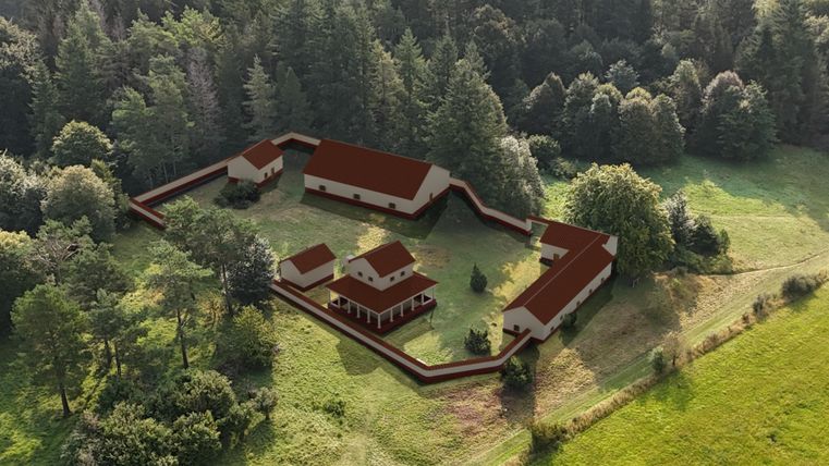 3D-Modell einer antiken Anlage in einer Waldlichtung, umgeben von Bäumen. Die Gebäude haben rote Dächer und sind von einer Mauer umgeben.