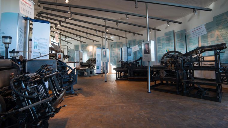 Ein historisches Museum mit großen Maschinen und Geräten. Die Wände sind mit Informationen und Bildern geschmückt.